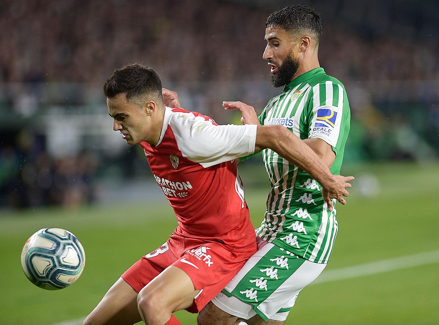 Real Betis' Nabil Fekir (right) clashing with Sevilla's Sergio Reguilon in November. The two sides will kick off the restart of La Liga today.