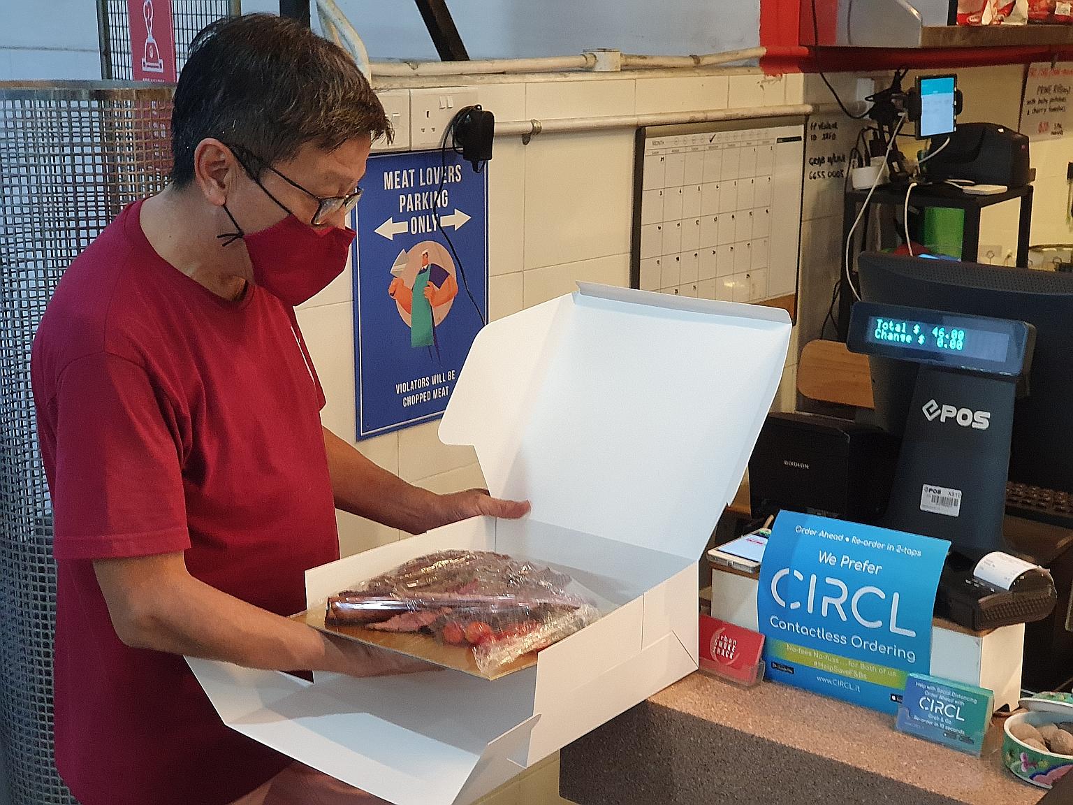 Mr Andrew Tay, 58, owner of hawker stall Urban Smokeshack, which sells smoked meat and seafood, preparing food for customers to collect. His stall is one of the firms using the CIRCL app, which enables restaurants and merchants to accept online order