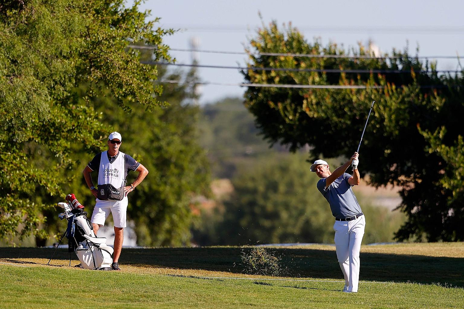 Justin Rose playing a shot on the 14th hole in the first round of the Charles Schwab Challenge at the Colonial Country Club in Texas. He shares the lead on seven-under 63 with Harold Varner III.