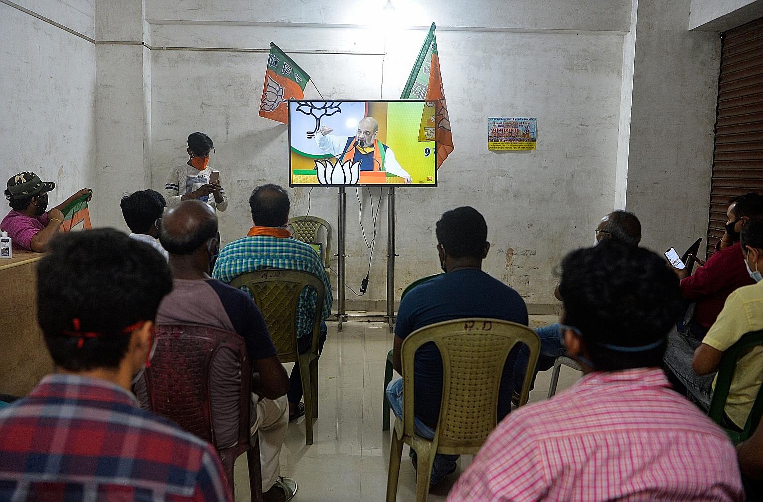 Supporters of the Bharatiya Janata Party watching Home Minister Amit Shah speak at an online rally in the city of Siliguri in India's north-eastern West Bengal state on Tuesday. The politician has held at least three rallies this week as part of a di