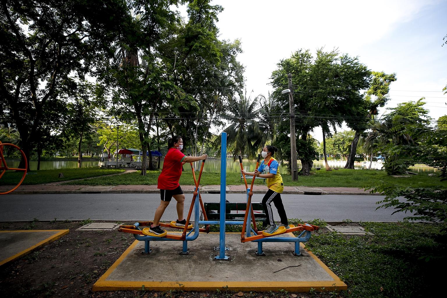 People in masks exercising in a park in Bangkok on Thursday. Thailand will lift a nationwide night-time curfew, from 11pm to 3am, on Monday as part of phase four of its easing of lockdown measures. PHOTO: EPA-EFE