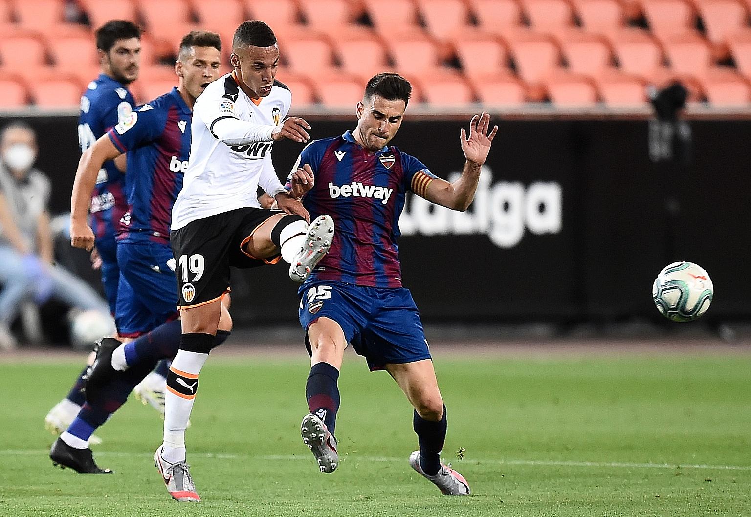 Valencia forward Rodrigo Moreno (in white) being challenged by Levante defender Sergio Postigo in their match at the Mestalla Stadium in Valencia on Friday. PHOTO: AGENCE FRANCE-PRESSE