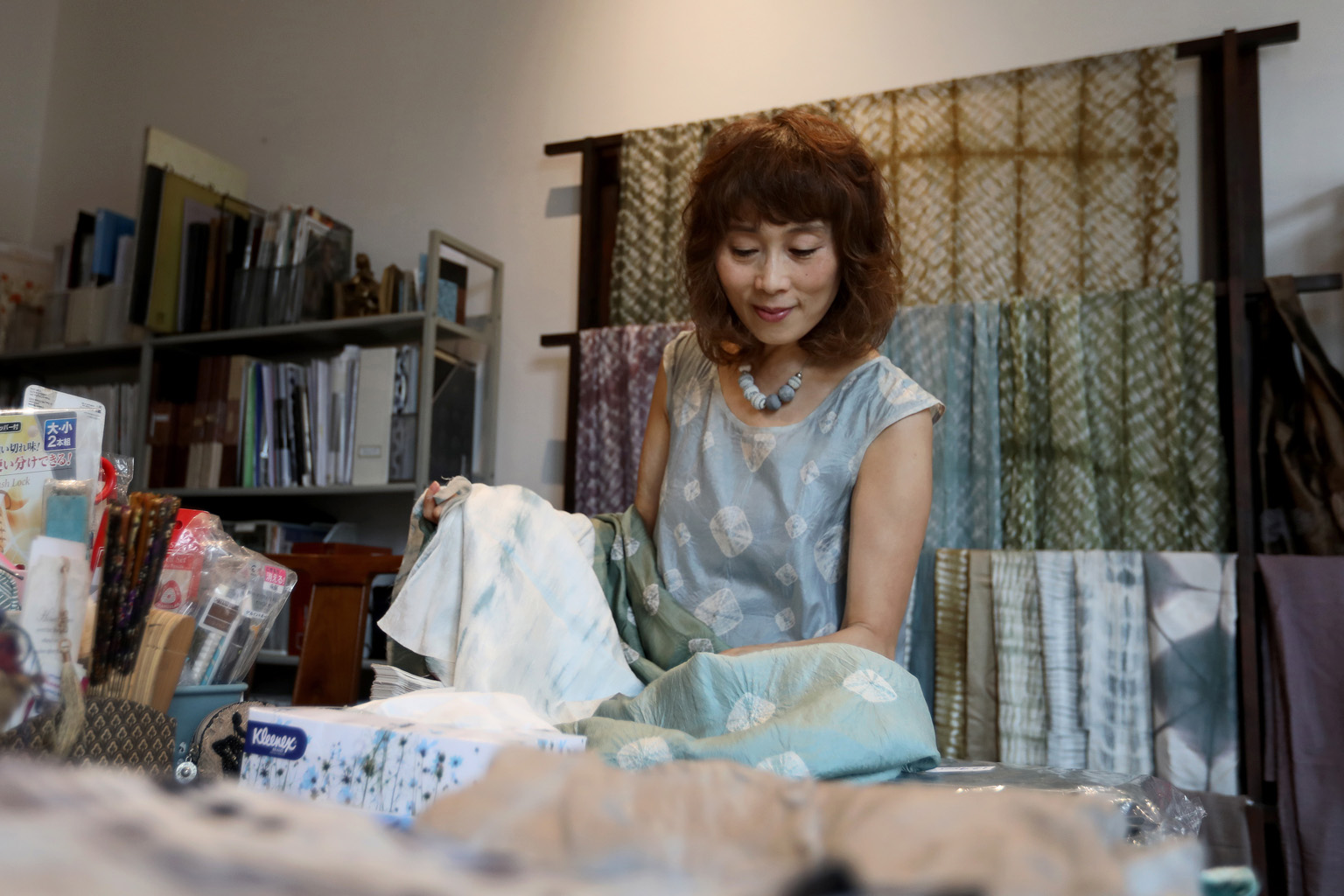 Ms Emiko Nakamura, founder and designer of emgallery, sorting through different fabrics in her home studio while her shop remains shut. She had to store her textiles and other products at home for nearly five months, while waiting for renovations on 