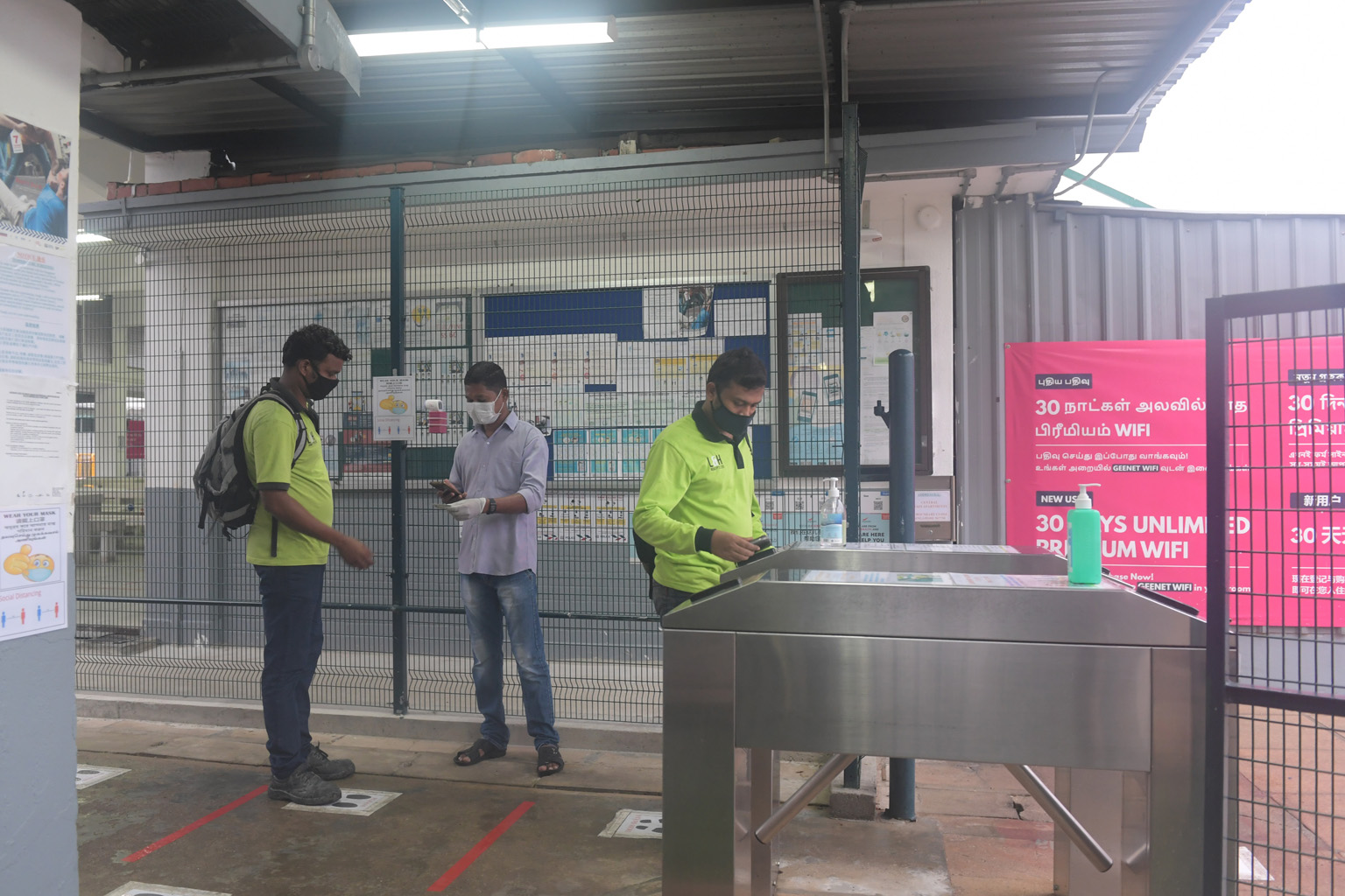 Migrant workers staying at Central Staff Apartments in Serangoon scanning their identification cards before leaving the dormitory for work. ST PHOTO: ALPHONSUS CHERN