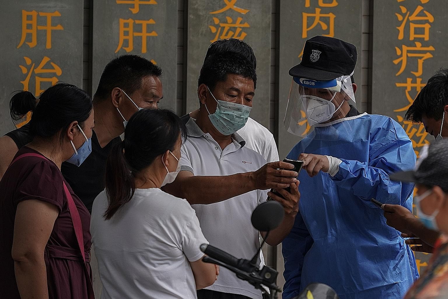 People who visited Xinfadi market or live near it using their mobile phones to make an appointment to be tested for Covid-19 at Youan Hospital in Beijing yesterday, after a spate of infections were linked to the market.