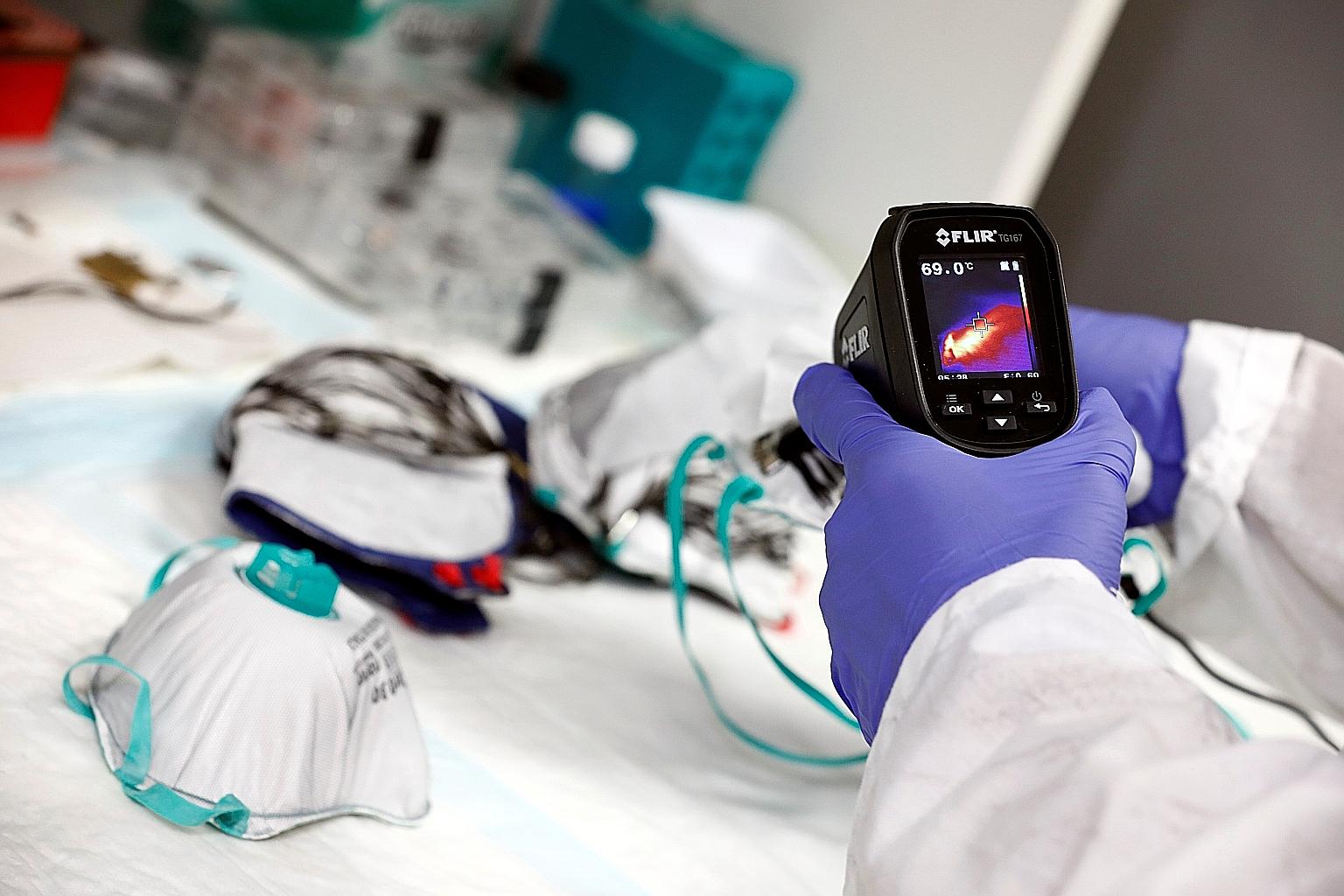 An Israeli researcher demonstrates the disinfecting process for the new self-cleaning mask that his team has invented, at a laboratory in Haifa, northern Israel, on June 10.