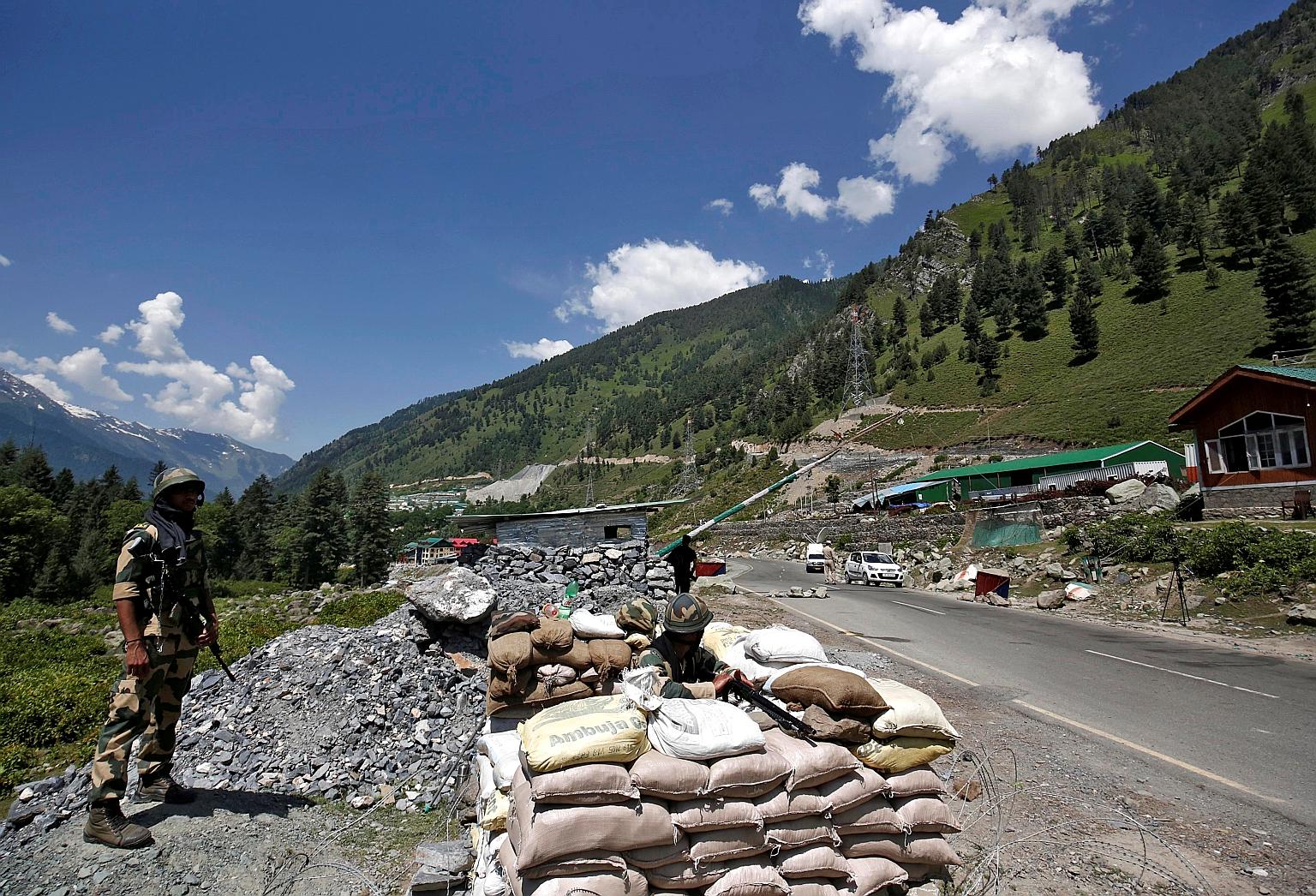 Soldiers from India's Border Security Force manning a checkpoint on a highway in Gagangeer in Kashmir's Ganderbal district, which leads to Ladakh, yesterday. PHOTO: REUTERS Top: Activists of the hardline Hindu organisation Bajrang Dal holding daggers