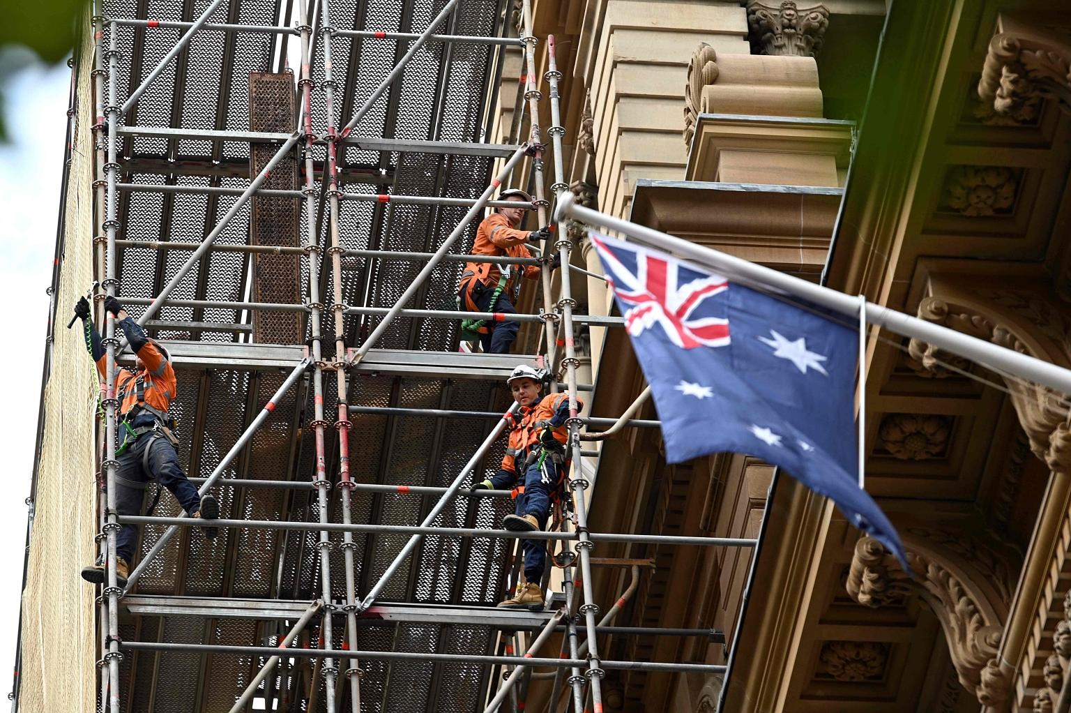 Workers at a construction site in Sydney's central business district yesterday. Australia lost some 227,000 jobs last month, more than twice the 100,000 expected. Separately in New Zealand, bank analysts predict the economy will contract by as much a
