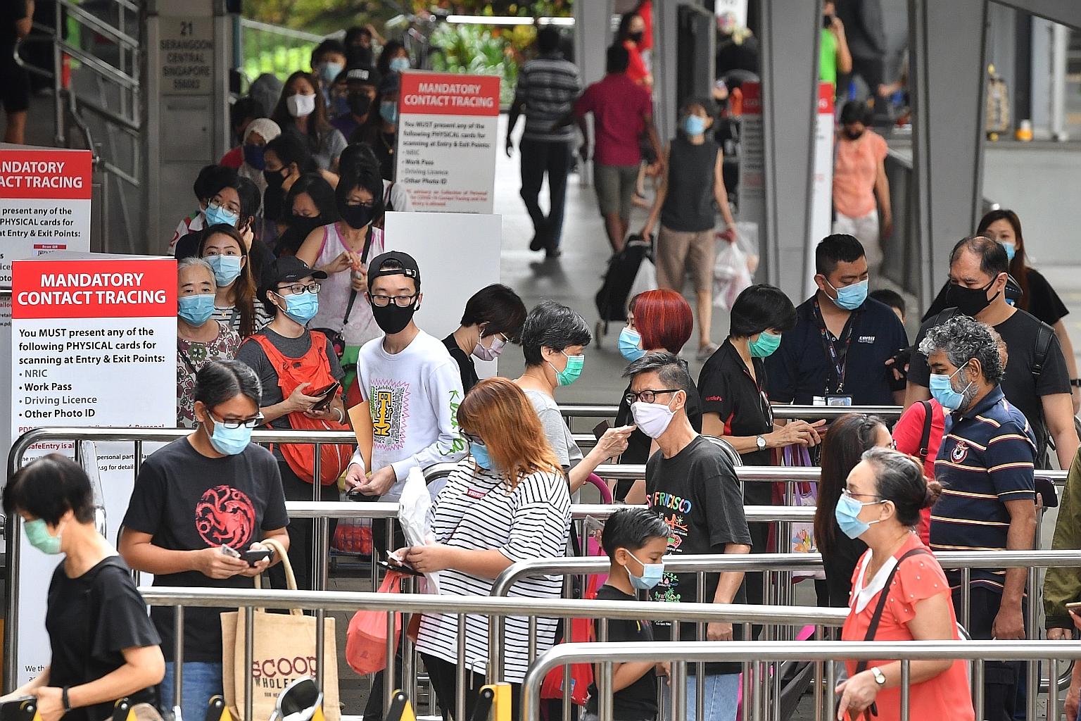 People queueing to use the SafeEntry system for contact tracing before entering Nex mall in Serangoon yesterday, when retailers across Singapore saw a steady flow of customers that lasted all day in some spots. ST PHOTO: CHONG JUN LIANG