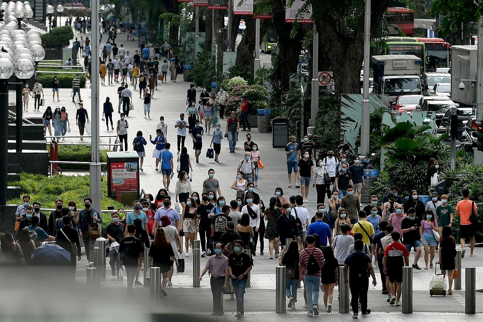 The city came alive again yesterday, the first day of phase two of Singapore's reopening. (From top) People thronging the streets of Orchard Road, albeit wearing face masks; shoppers leaving Tangs department store with their purchases; and customers 