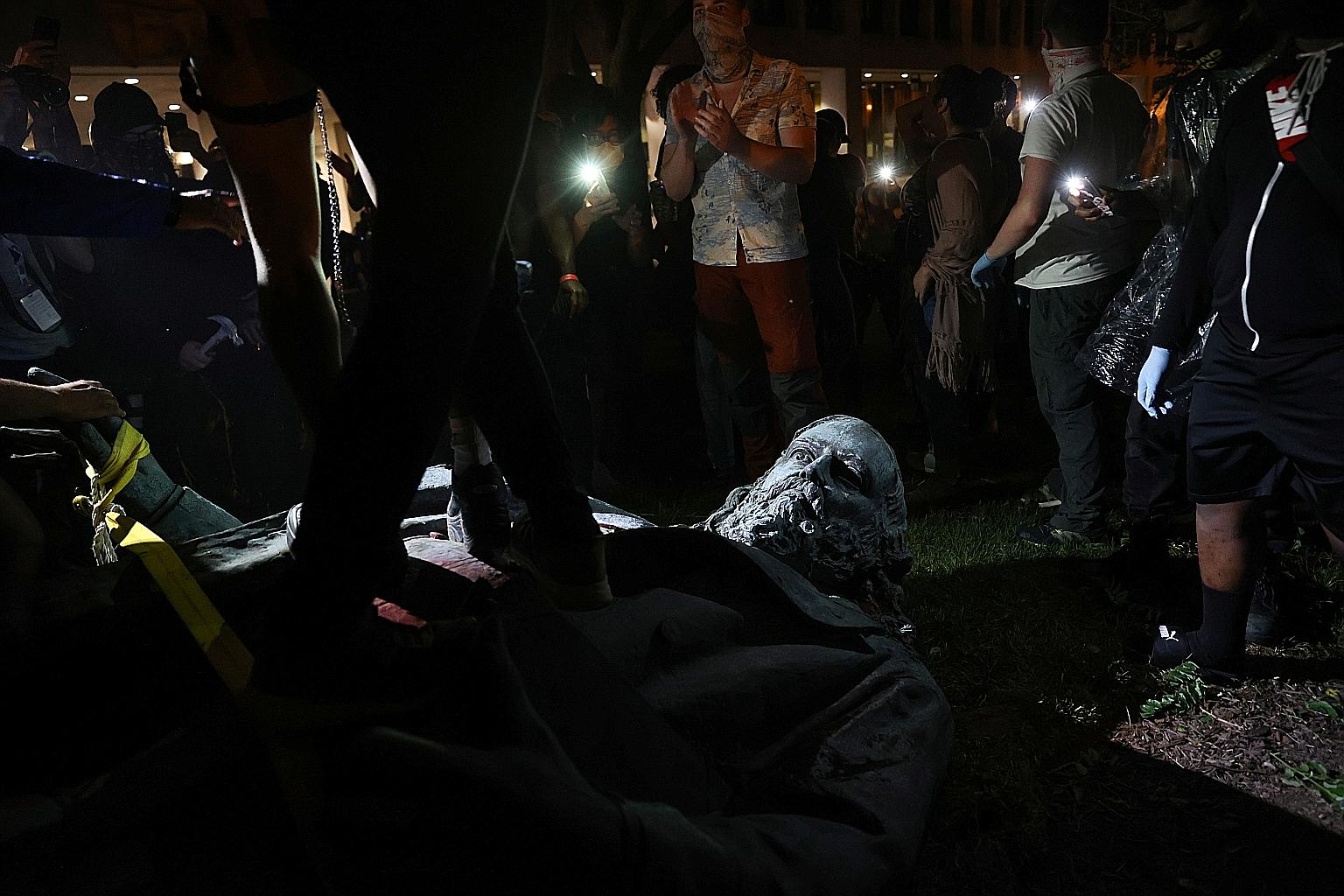 Protesters walking on the toppled statue of Confederate general Albert Pike during an event in Washington DC on Friday to commemorate Juneteenth, which marks the end of slavery in the country.