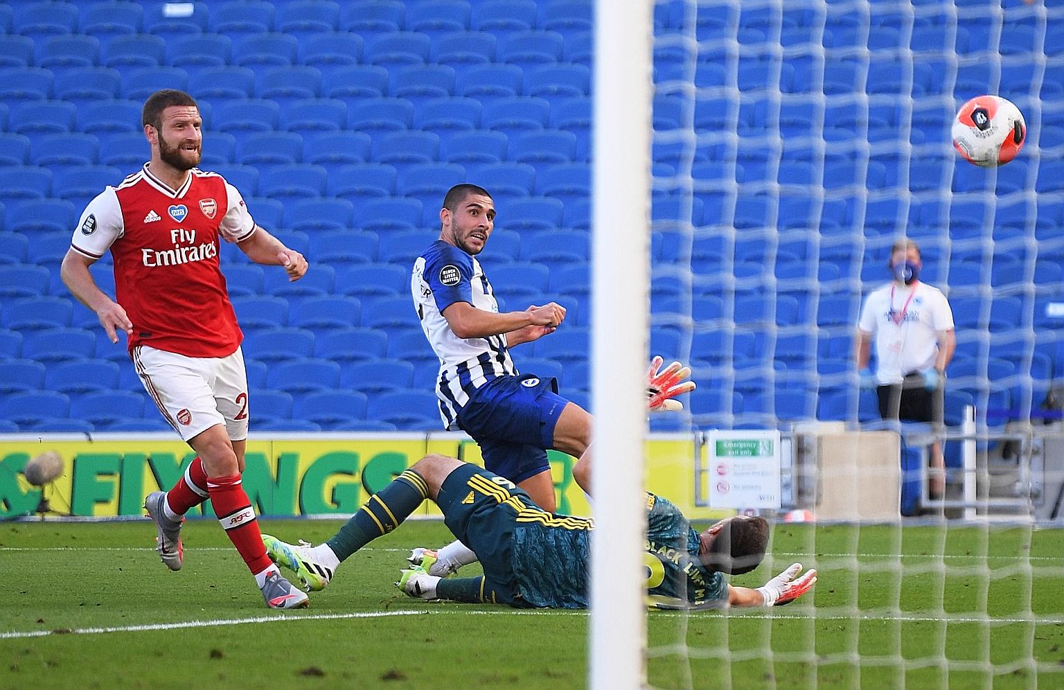Brighton's Neal Maupay getting to the ball ahead of Arsenal's substitute goalkeeper Emiliano Martinez to tuck it home with virtually the last kick of the Premier League game. Martinez came on after the French striker's challenge on Bernd Leno resulte