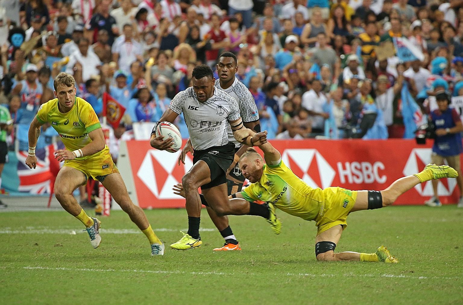 Fiji's Amenoni Nasilasila skipping past the tackle of Australia's Tom Connor during the final of the Singapore Sevens in 2018. The event's fate this year is hanging in the balance due to the coronavirus pandemic.