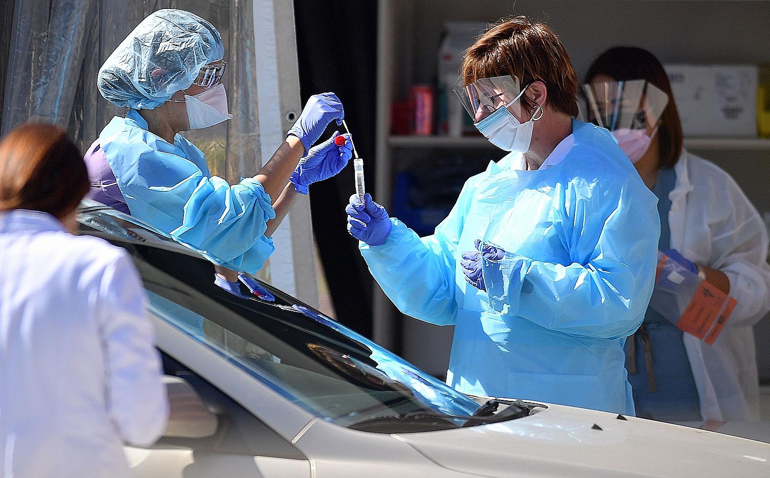 Medical workers collecting samples at a drive-through testing facility in San Francisco in March. The United States is among countries that have administered saliva tests to detect Covid-19. PHOTO: AGENCE FRANCE-PRESSE