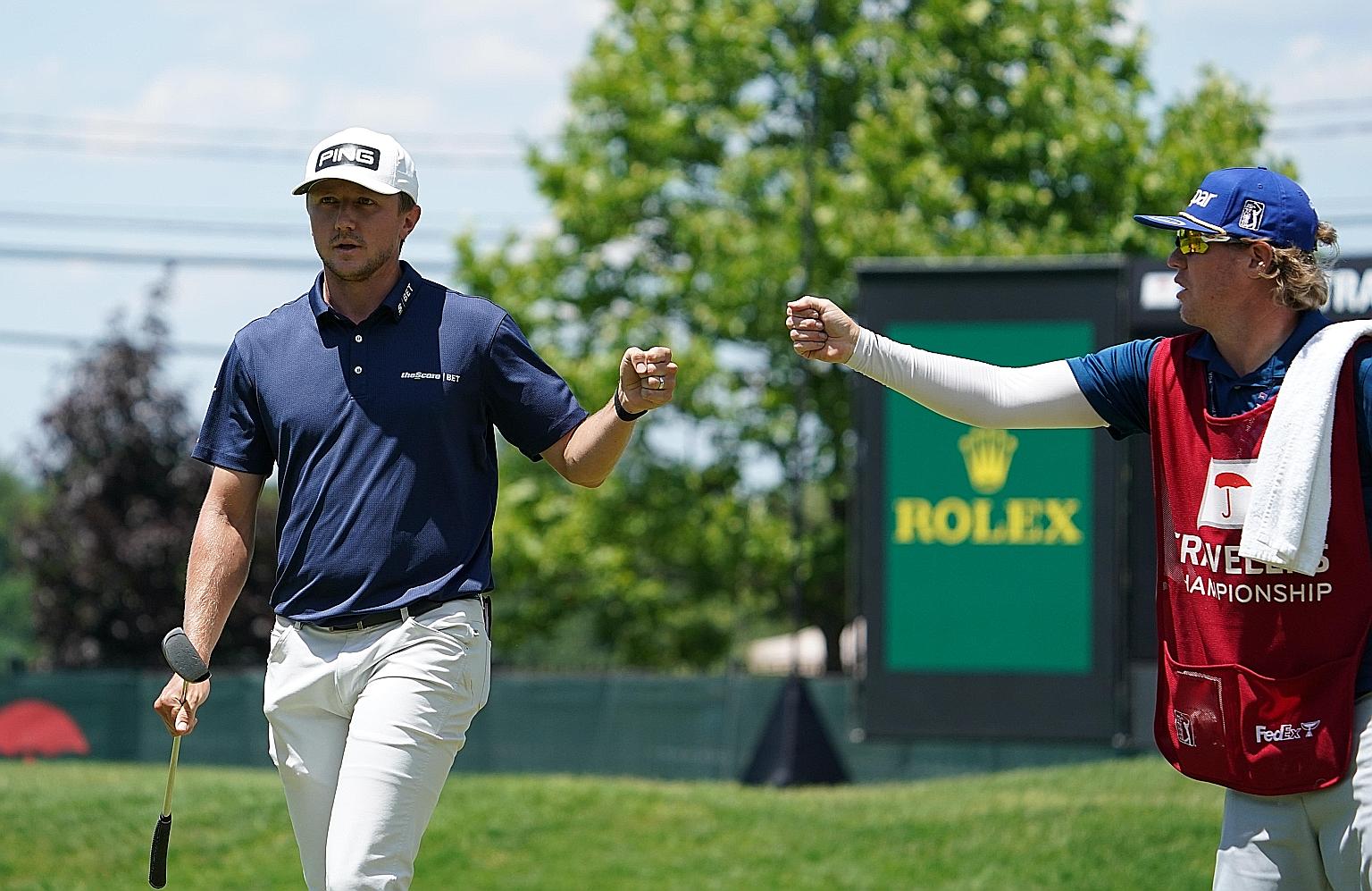 Canadian golfer Mackenzie Hughes fist-bumps his caddie after another good shot in a superb opening round of 60 at the Travelers Championship in Cromwell, Connecticut. 