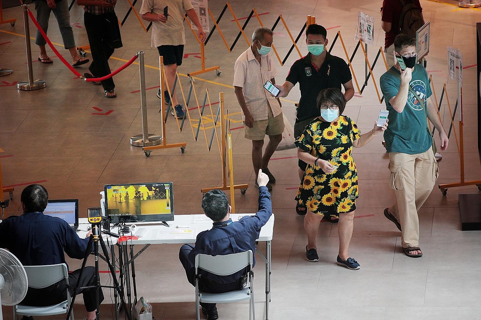 People showing security guards they had checked in using the SafeEntry system as they entered SingPost Centre yesterday. The Health Ministry reminded the public to limit social gatherings to no more than five people and said the behaviour of the man 