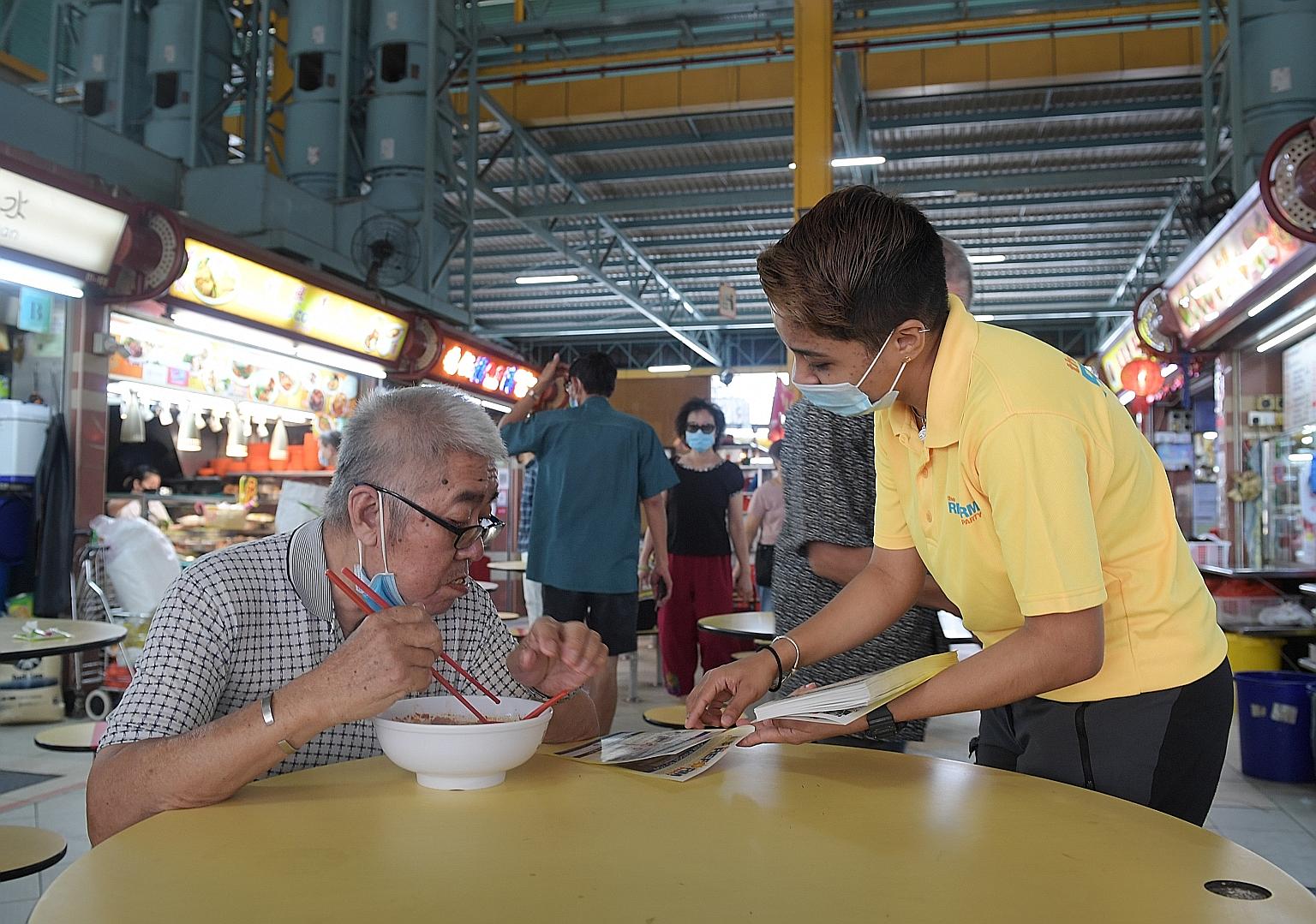Ms Tyeisha Syaquilla Ayub, 23, from the Reform Party, distributing fliers at the Cheng San food centre yesterday morning.