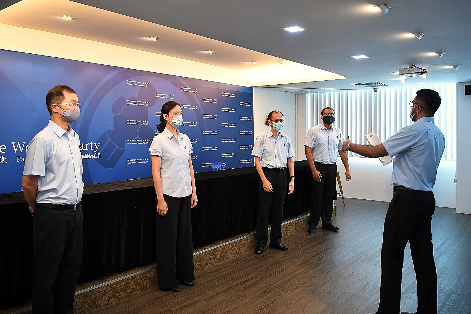 Workers' Party chief Pritam Singh (right) directing the party's new candidates (from left) Mr Louis Chua, Ms Nicole Seah, Mr Yee Jenn Jong and Mr Muhammad Azhar Abdul Latip at the opposition party's headquarters on Thursday. ST PHOTO: KUA CHEE SIONG
