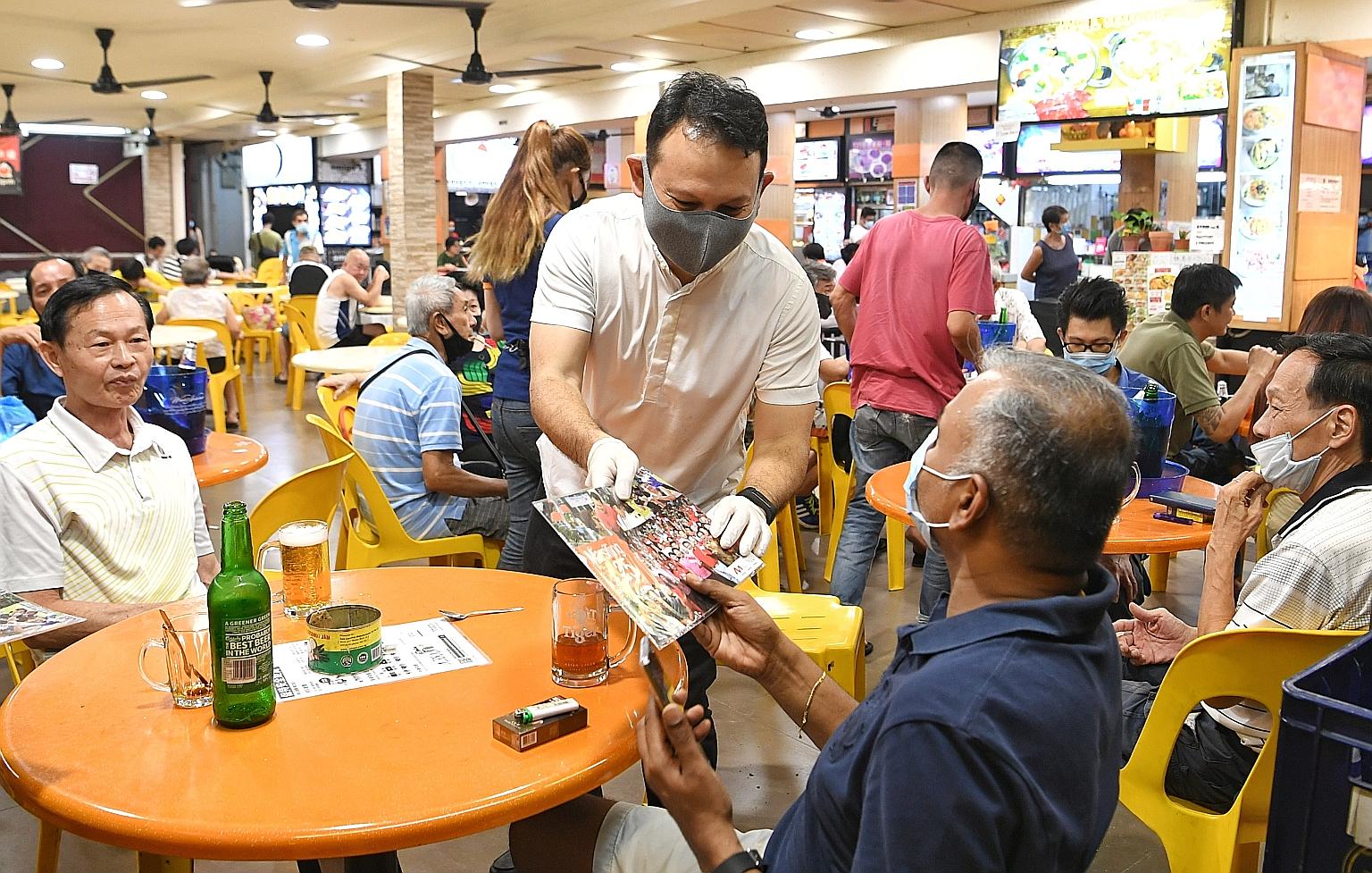 Minister of State for Manpower and National Development Zaqy Mohamad speaking to a resident at a coffee shop in Marsiling Rise during a walkabout yesterday.