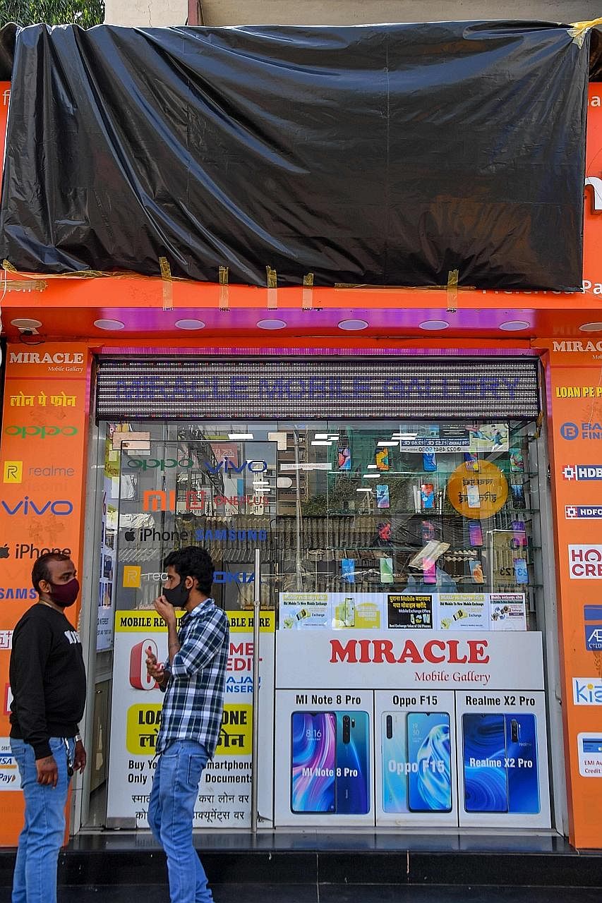 Indian soldiers in Ladakh on Thursday, following a deadly clash on the disputed border between India and China earlier this month. PHOTOS: AGENCE FRANCE-PRESSE A tarpaulin covering the signboard of a shop in Mumbai selling mobile phones from Chinese 