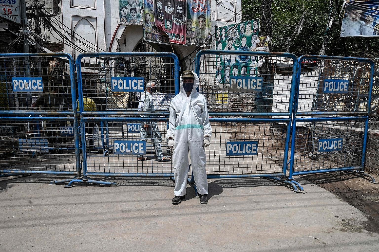 A policeman standing guard at a barricade at a restricted area sealed by the authorities in Lahore, Pakistan, last Thursday. It is evident that, much like the global trend in countries where Covid-19 cases have soared, Pakistan's daily cases and deat