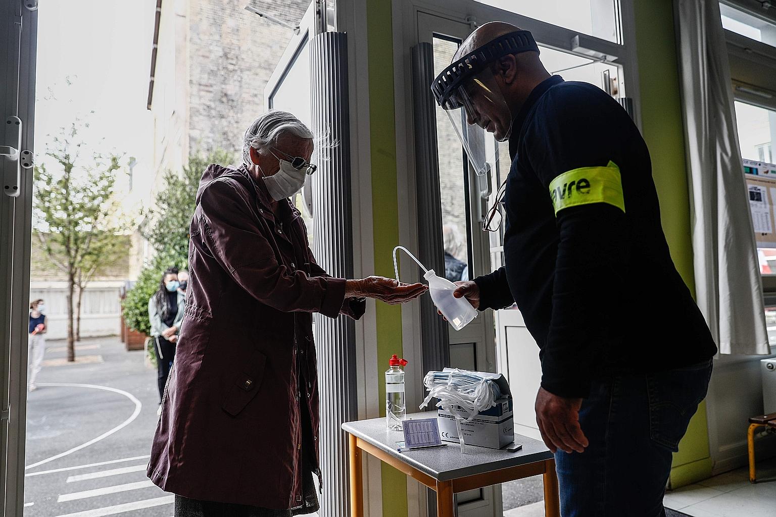 A voter washing her hands ahead of casting her ballot in Le Havre, western France, yesterday. Some 16.5 million people are registered to vote, with those turning out required to wear a mask.