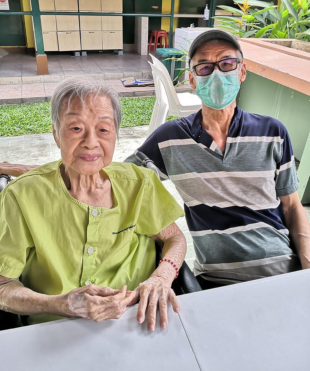 Madam Yap Lay Hong with her second son Alan Ho last Thursday at a designated outdoor area at Lee Ah Mooi Old Age Home, away from other residents.