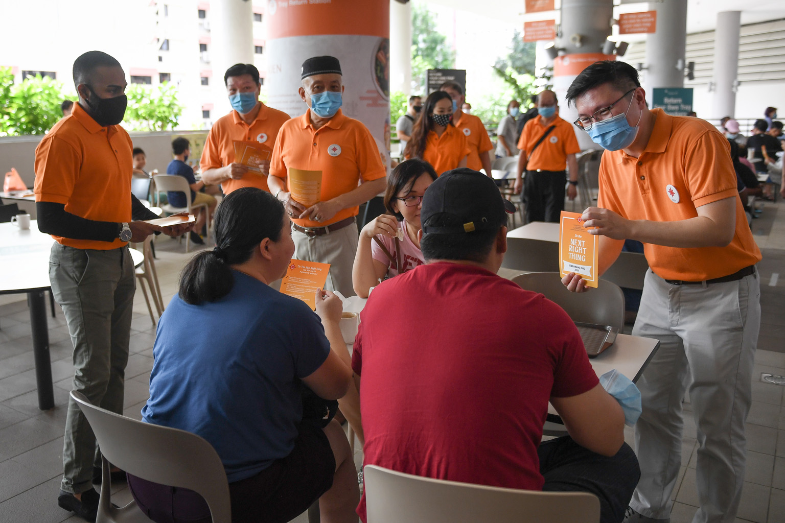 (From far left, in orange) The NSP's Mr Sathin Ravindran, Mr Sebastian Teo, Mr Yadzeth Hairis and secretary-general Spencer Ng on a walkabout at Kampung Admiralty Hawker Centre in Sembawang GRC yesterday. They are expected to be in the NSP's line-up 