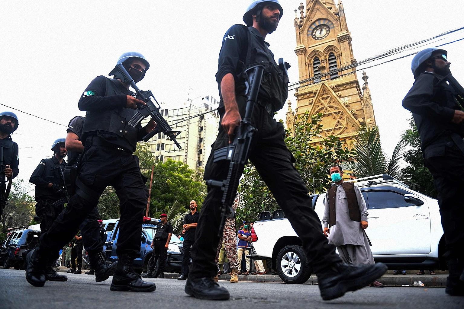 Police commandos patrolling near the Pakistan Stock Exchange in Karachi after an attack on the building by gunmen yesterday.