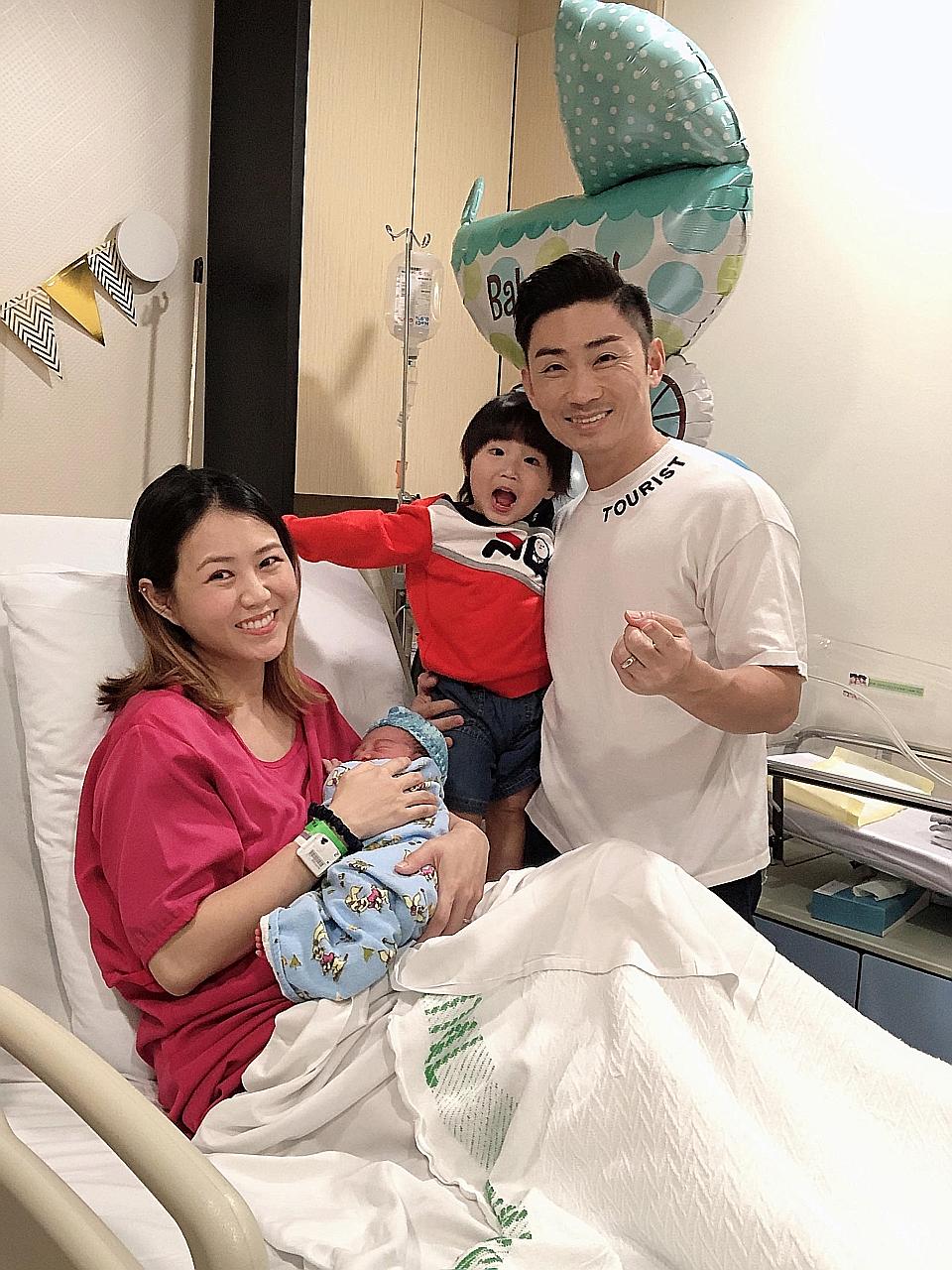 Local singers Tay Kewei and Alfred Sim with their elder son Momo and their new baby.