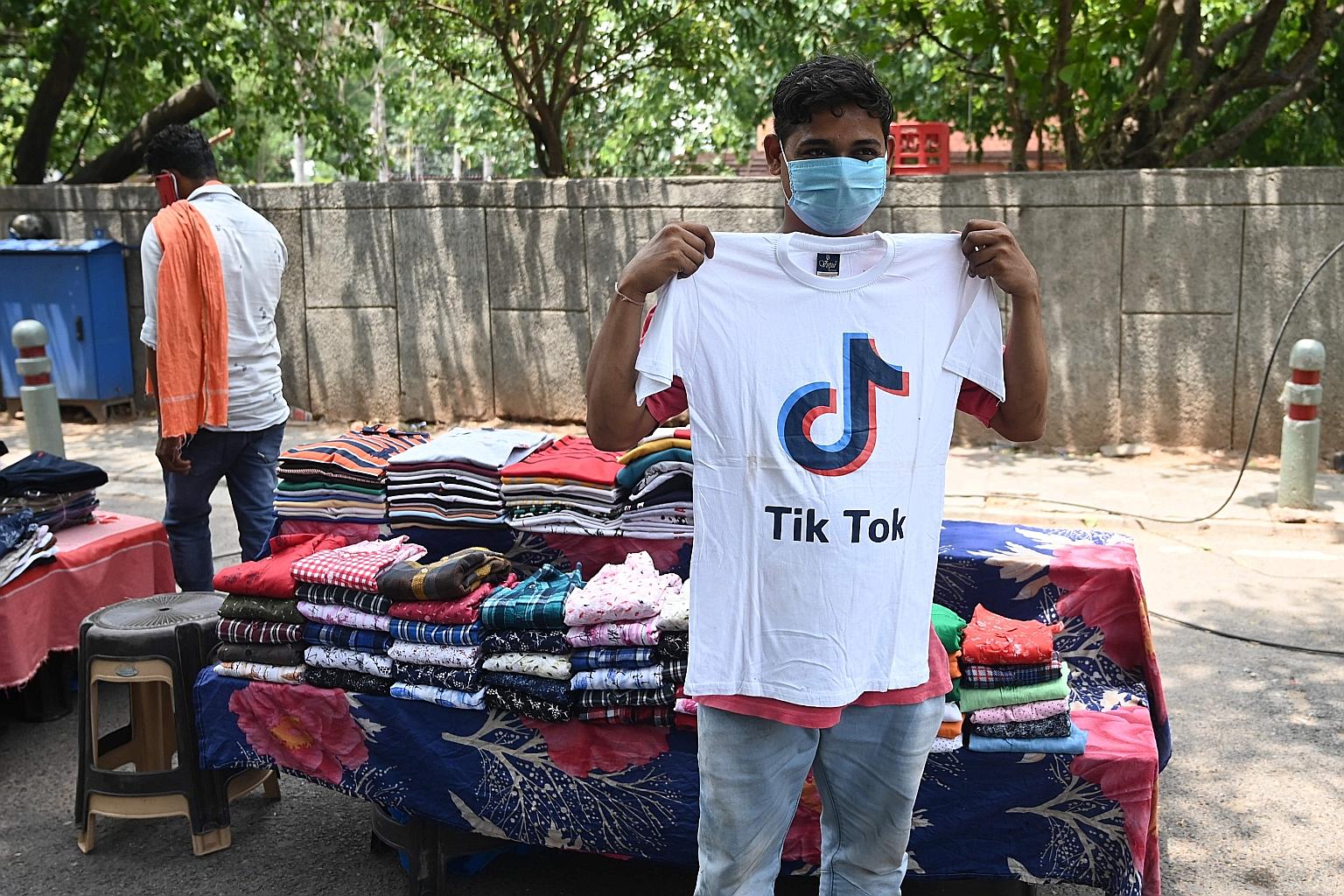 A garment vendor in New Delhi holding up a TikTok T-shirt yesterday. Of the Chinese apps India has banned, TikTok is the most popular, with about 200 million active users in the country. The move could affect how millions of Indians work and play.