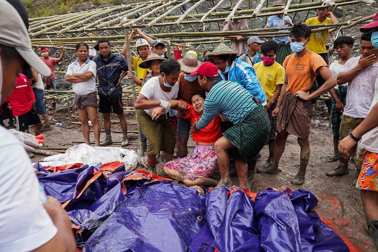A woman grieving over the bodies of miners recovered in a jade mining site in Hpakant, in Myanmar's Kachin state, yesterday.