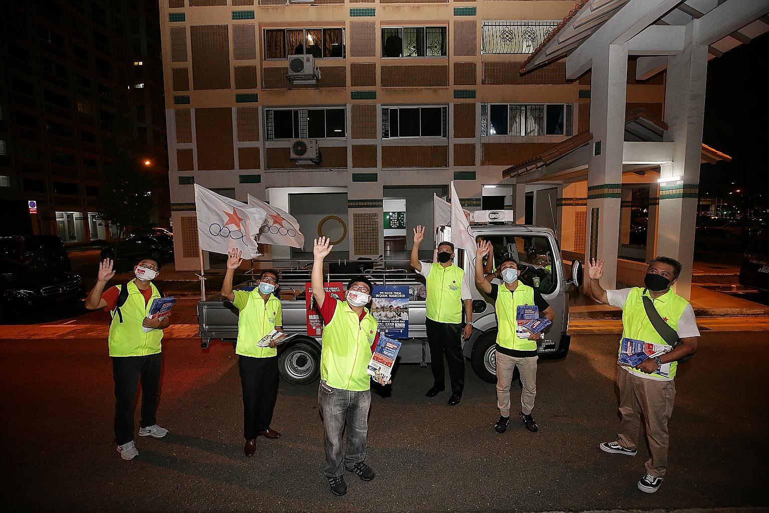 Singapore Democratic Alliance's Mr Desmond Lim (third from left), who helms the team contesting in Pasir Ris-Punggol GRC, waving to residents of Pasir Ris Street 51 from their campaign lorry yesterday. ST PHOTO: KEVIN LIM