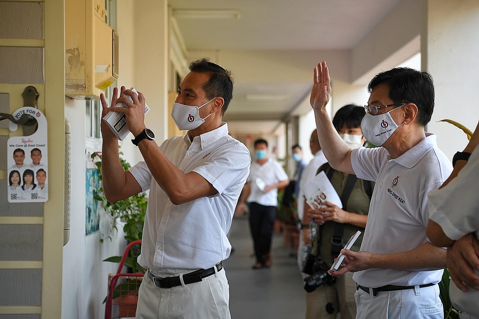 Deputy Prime Minister Heng Swee Keat and new face Tan Kiat How greeting residents during a block visit in Bedok North Street 1 yesterday.