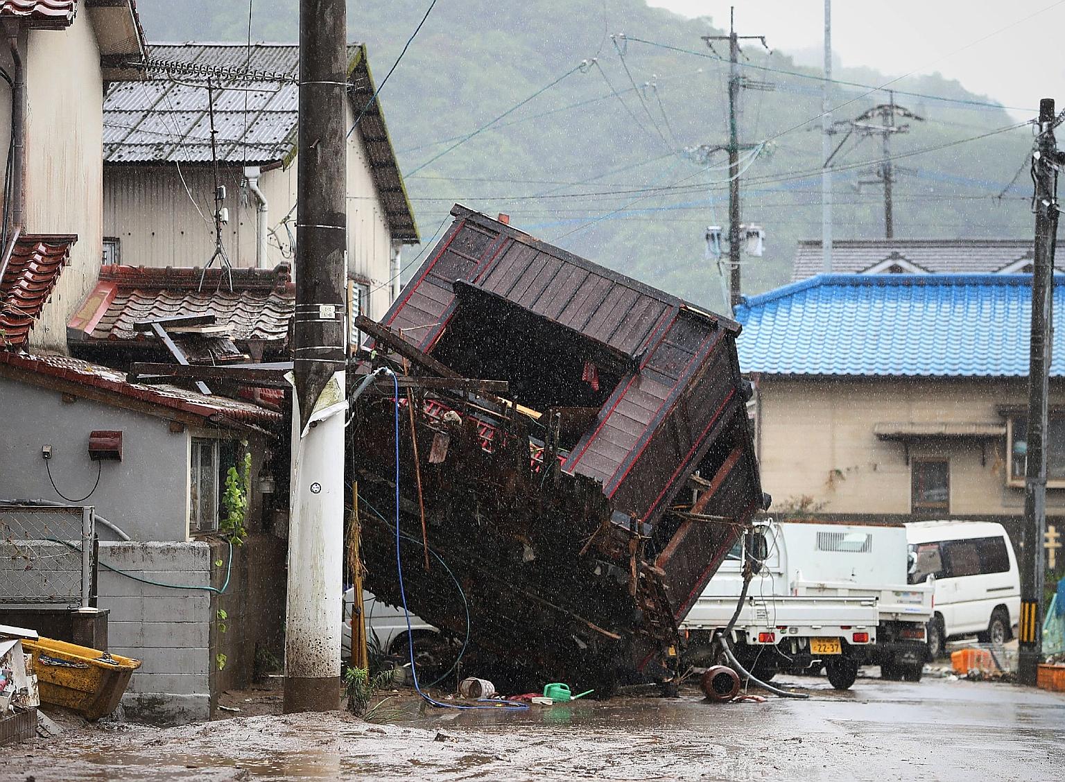 Residents trying to clean up their home damaged by floodwaters due to the torrential rain in Hitoyoshi yesterday. Communities along the Kuma River, which passes through Hitoyoshi, have been hit hard by flooding and over 200,000 people have been urged