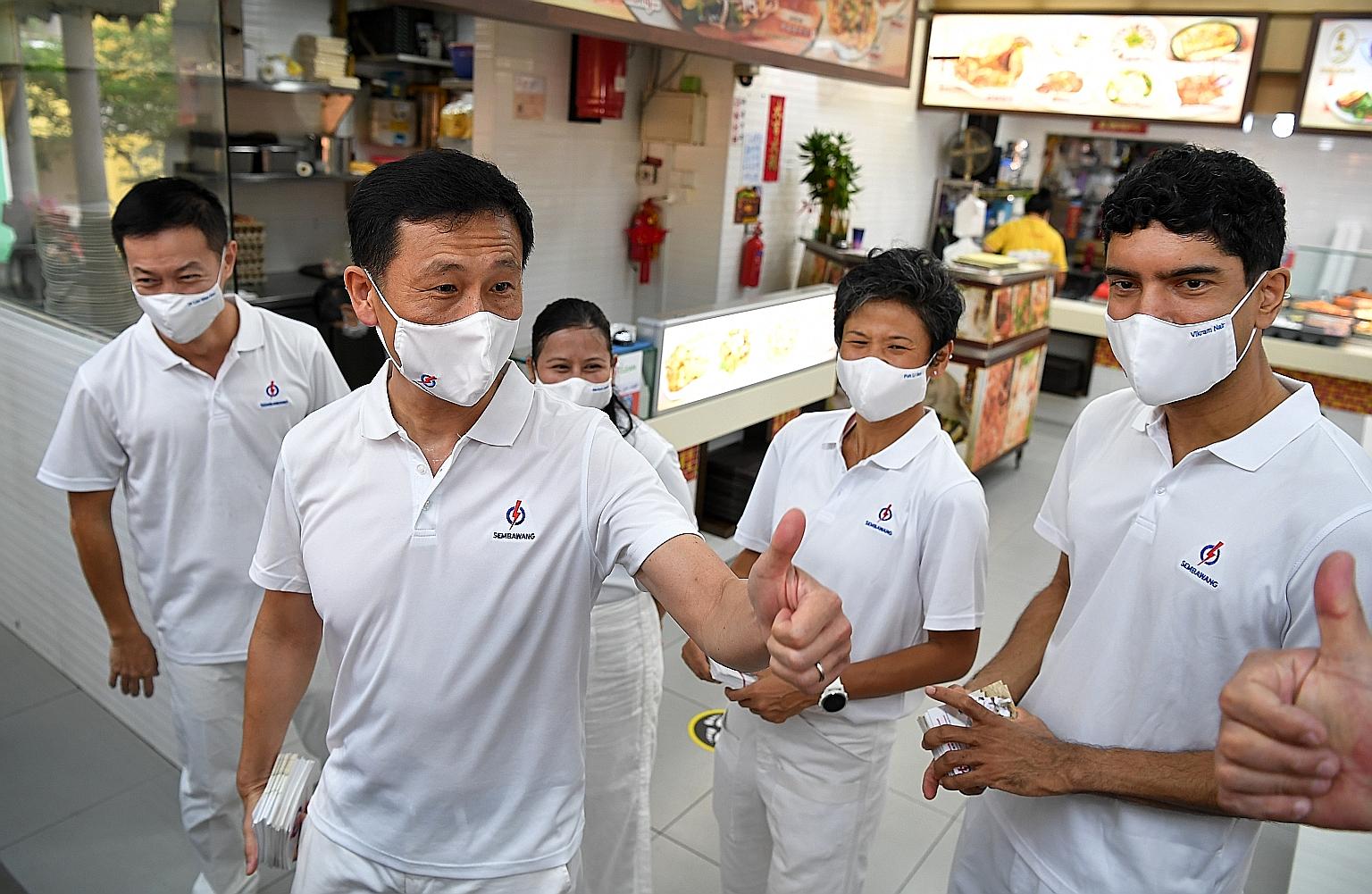 Education Minister Ong Ye Kung responding to a resident with a thumbs up during a walkabout at a coffee shop in Sembawang Drive last Wednesday. Mr Ong is helming the People's Action Party team contesting in Sembawang GRC, which also includes (from le