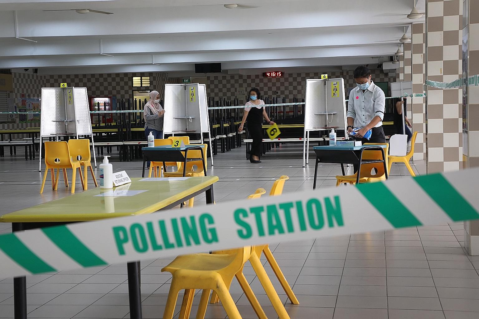 At Chung Cheng High School in Goodman Road yesterday, public servants set up the polling station, putting in place safe-distanced polling booths, temperaturetaking points, sanitising products and floor markings for spaced queues to ensure the safety