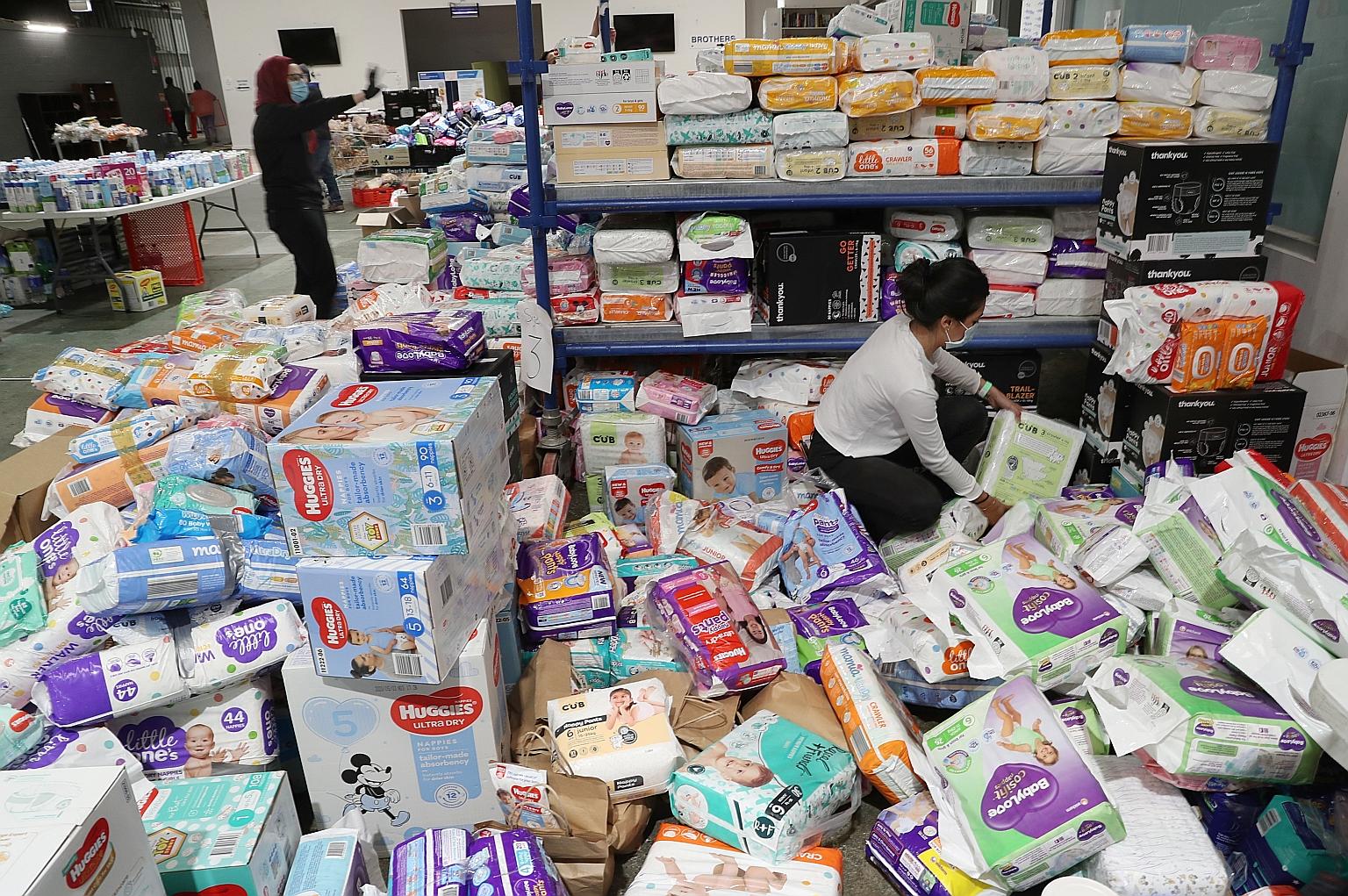Volunteers in Melbourne, Victoria, sorting out donated supplies for residents of the Alfred Street public housing tower, which remains under tight lockdown due to the coronavirus pandemic. Victoria reported 216 new coronavirus cases yesterday. PHOTO: