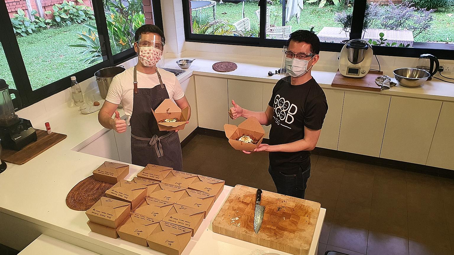 MasterChef Singapore winner Zander Ng (left) and GoodHood.SG founder Nigel Teo, with meals prepared by Mr Ng under the #KindCooks initiative, which connects neighbours who cook with those in need of meals. The initiative has seen 40 volunteers provid
