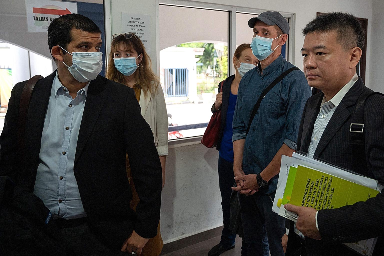Al Jazeera journalists - reporter/senior producer Drew Ambrose (left), executive producer Sharon Roobol (third from right) and cameraman Craig Hansen (in cap) - at a police station in Kuala Lumpur last Friday. PHOTO: AGENCE FRANCE-PRESSE