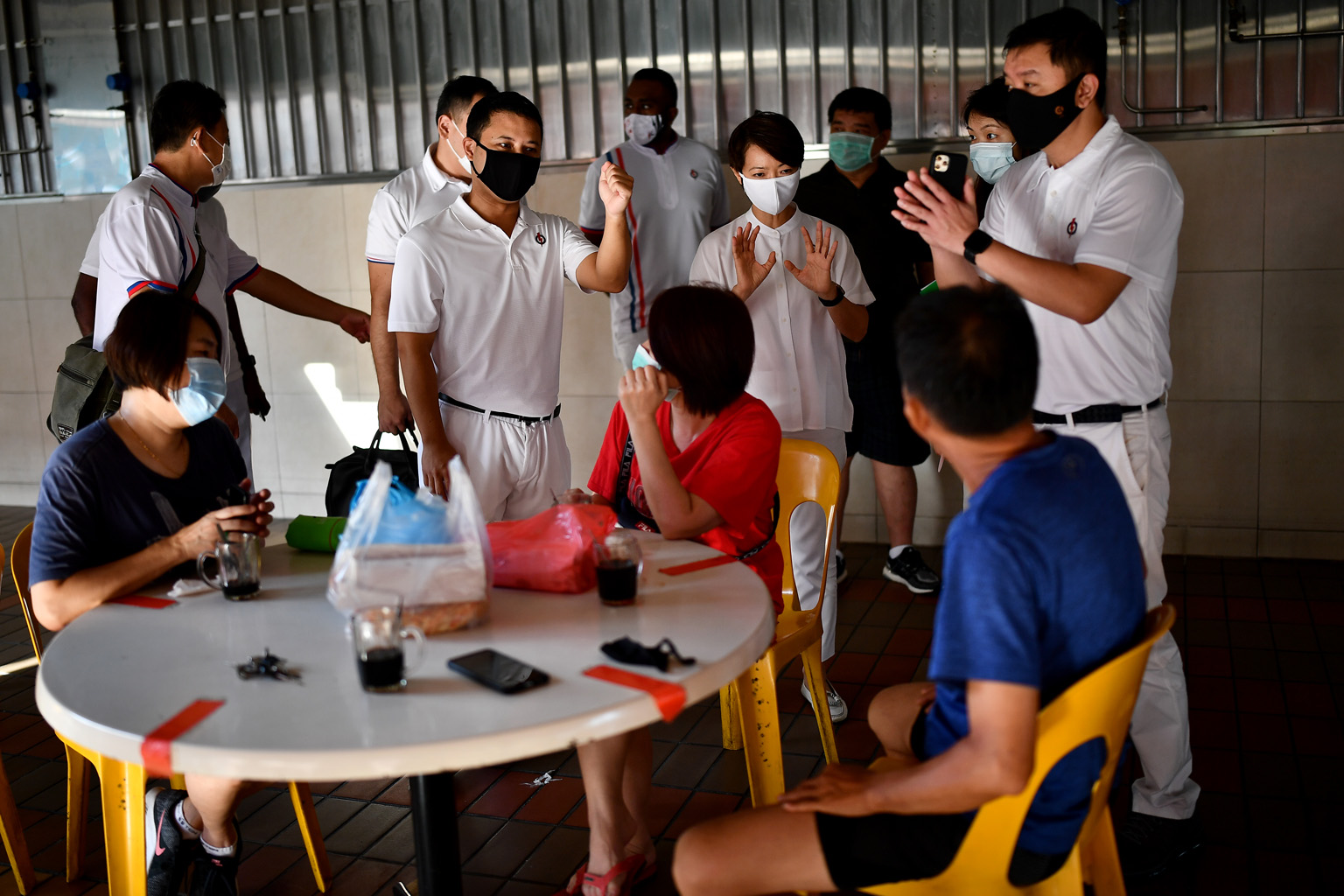Above: Minister for Social and Family Development Desmond Lee (standing, centre) and Ms Foo Mee Har, who are part of the newly elected People's Action Party (PAP) team in West Coast GRC, interacting with residents in a coffee shop at Block 964 Jurong