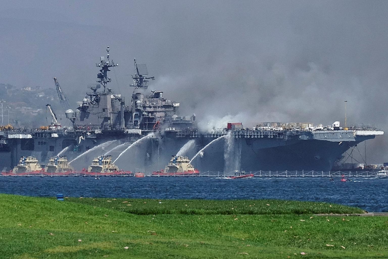 Firefighting boats spraying water onto the USS Bonhomme Richard as smoke rose from a fire on board the amphibious assault ship at Naval Base San Diego on Sunday. The blast was believed to have been triggered by the rapid initial release of heat from