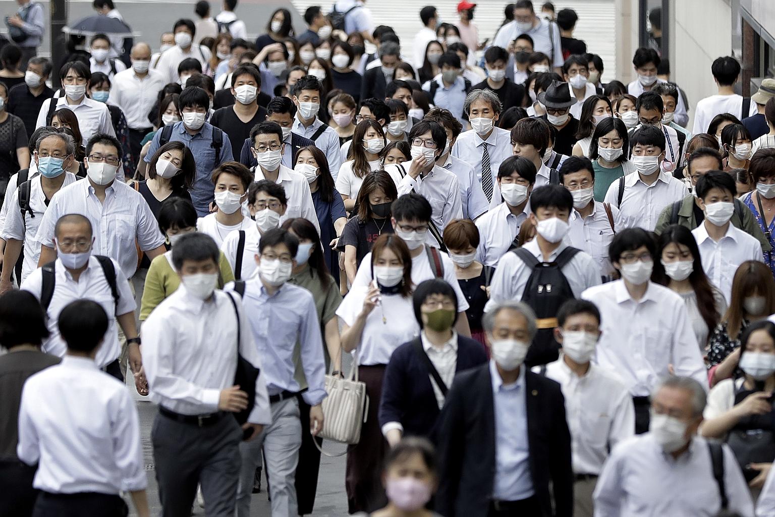 Pedestrians wearing masks in the Shinjuku district of Tokyo last Friday. Japan is forging ahead with further steps to reopen the economy.