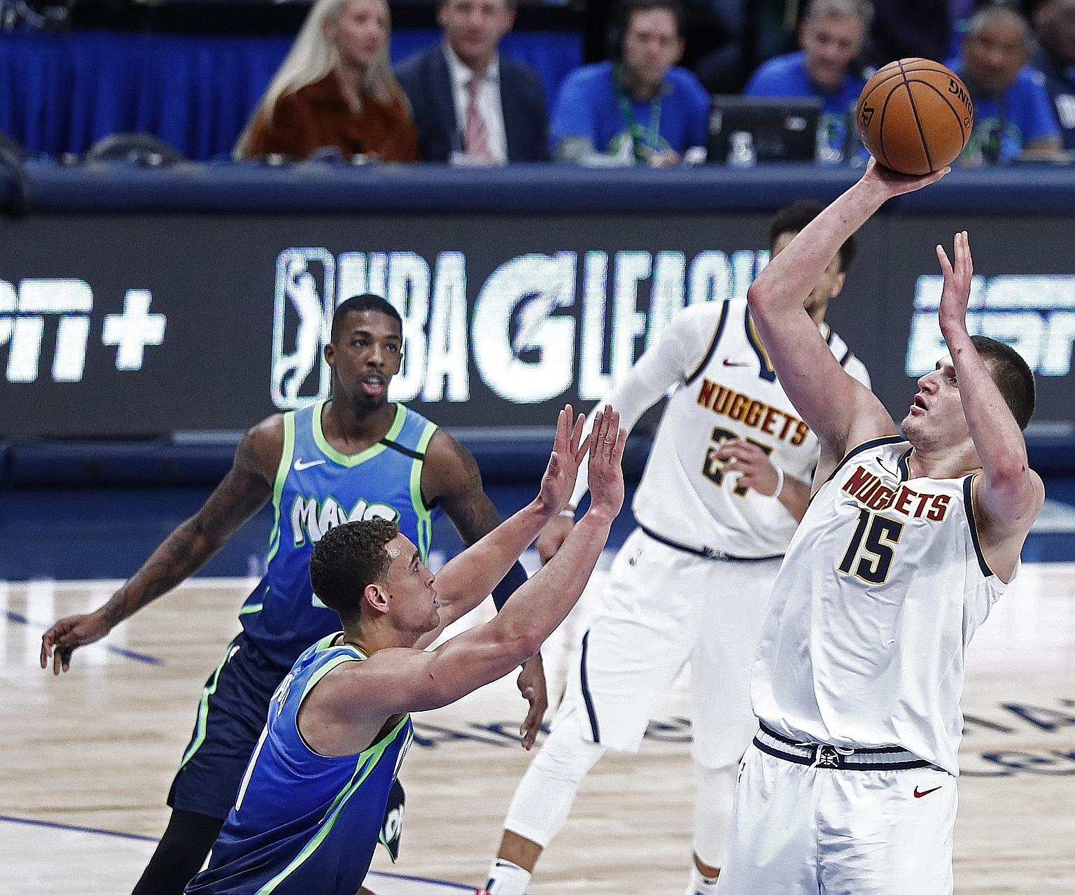 Denver Nuggets player Nikola Jokic (far right) taking a shot against Dallas Mavericks' Dwight Powell during their NBA game at the American Airlines Centre in Dallas in January. Jokic tested positive for Covid-19 in Serbia last month and completed his