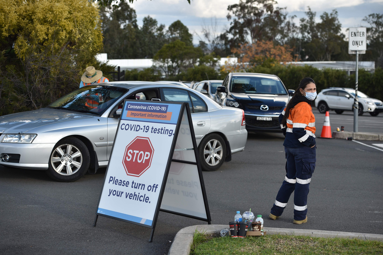 People queueing in their vehicles for Covid-19 testing at a hotel in Sydney. The federal government has cut the weekly number of Australians who can return from overseas from about 7,000 to 4,000.