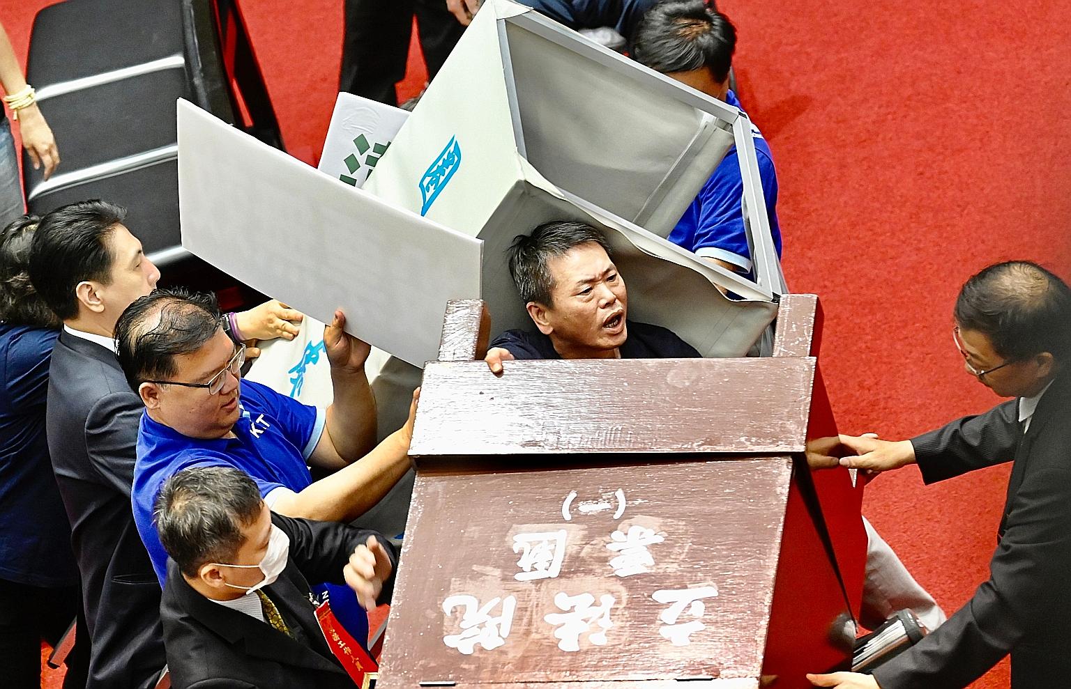 Taiwan's opposition party lawmakers trying to remove a voting booth in Parliament yesterday to block the ruling party's lawmakers from casting ballots for the nomination of President Tsai Ing-wen's senior aide, Ms Chen Chu, to a top government watchd