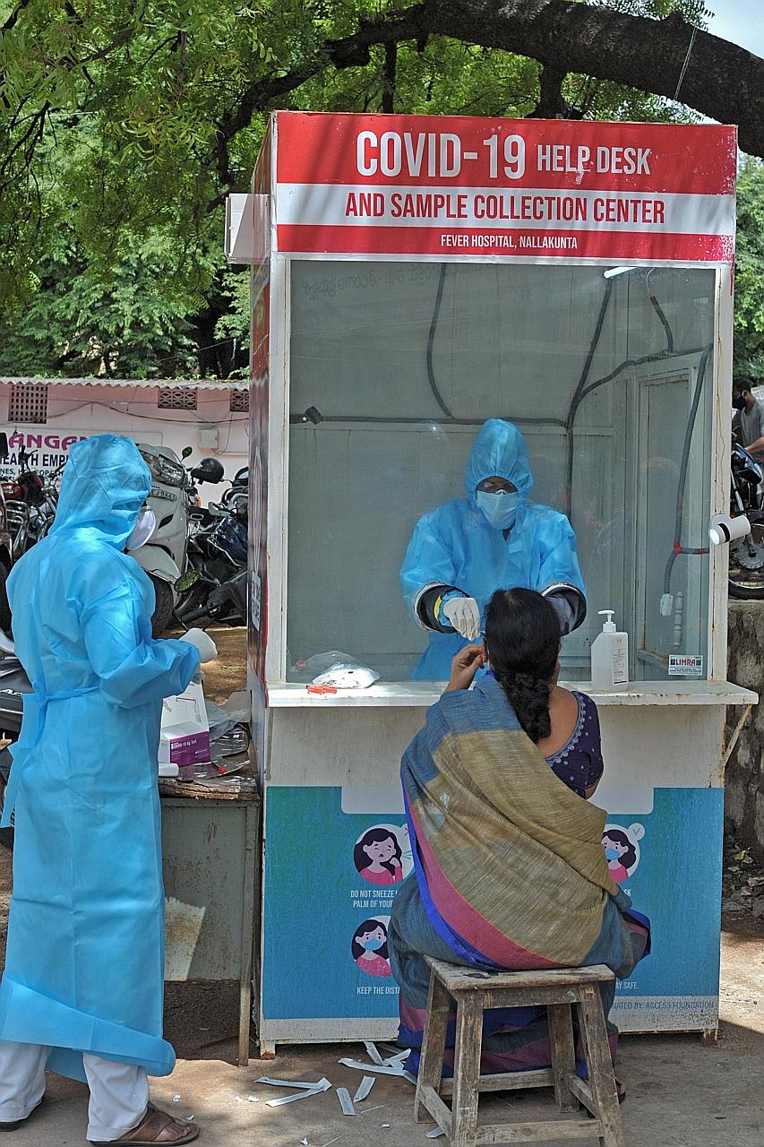 Health workers collecting swab samples from people at a free government testing centre in the city of Hyderabad in southern India yesterday. More than 25,000 people in India have died from the disease so far.