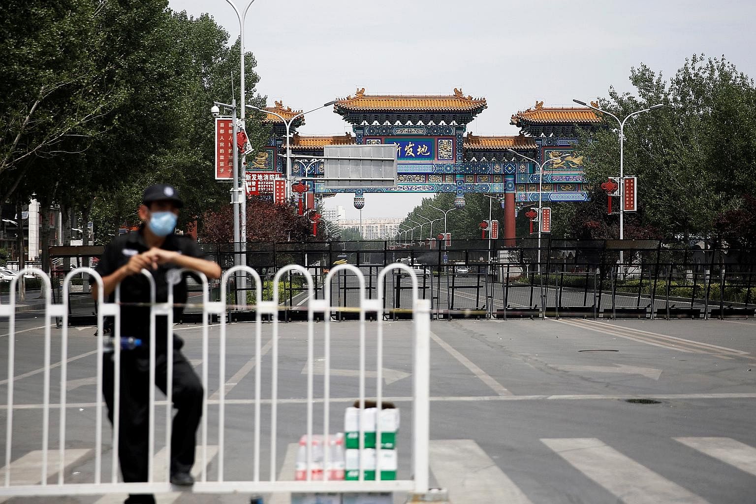 A security officer at the blocked entrance to the Xinfadi wholesale market in Beijing on June 16. When the first case there was detected on June 11, Beijing swiftly closed the market, which houses some 8,000 stallholders and workers and is visited by