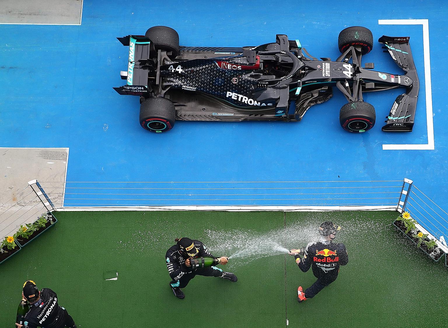 Mercedes' Lewis Hamilton and Red Bull's Max Verstappen, winner and runner-up respectively at yesterday's Hungarian Grand Prix, spraying each with champagne on the podium as third-placed Mercedes driver Valtteri Bottas gets ready to join in the fun.