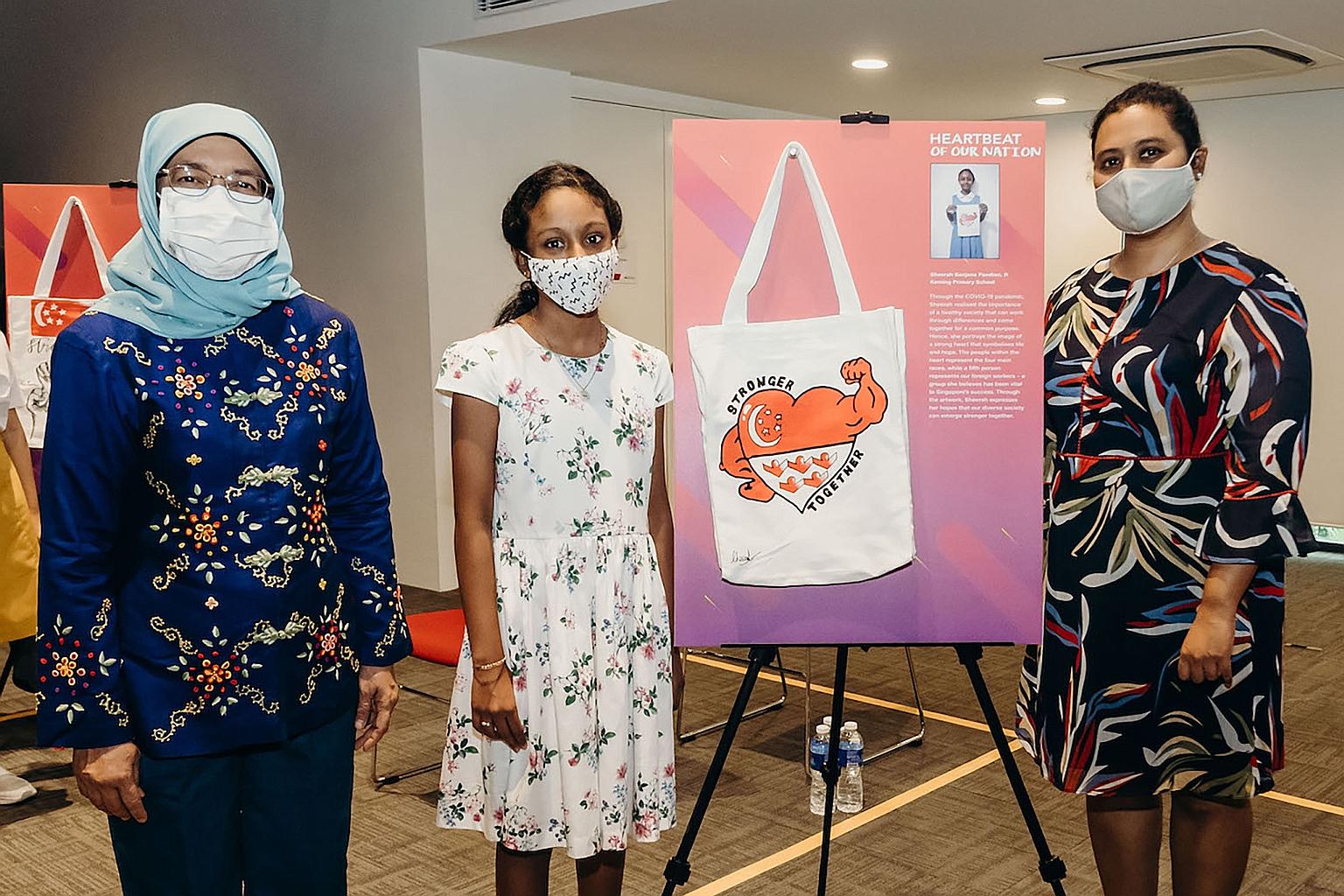 Keming Primary 5 pupil Sheerah Sanjana Pandian, seen here with her mother Shireen Pandian (right), 45, presenting her design on the NDP2020 pack to President Halimah Yacob. The 11-year-old dedicated her drawing to the foreign workers here. Describing